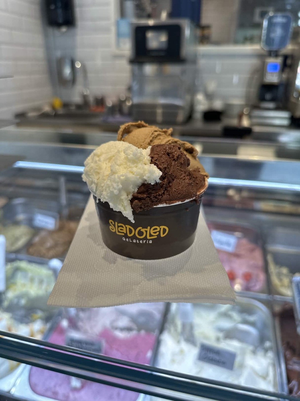 Gelatobägare med Sladoleds logga framför glasdisken